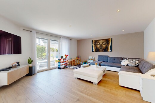 salon avec télévision, cloison sèche, drywall, sol en finition bois, et wood finish floor