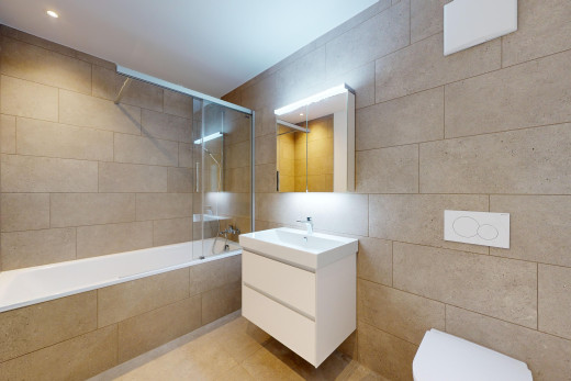 bad mit toilette, fliesenwand, fliesenboden, und kombiniertes bad / dusche