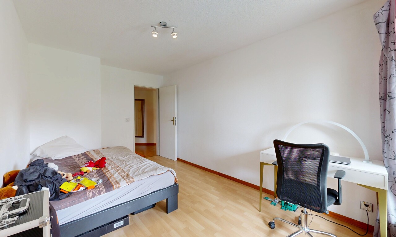 room with a desk and light wood-style flooring