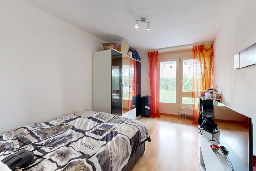 chambre avec télévision, drywall, cloison sèche, wood finish floor, et sol en finition bois