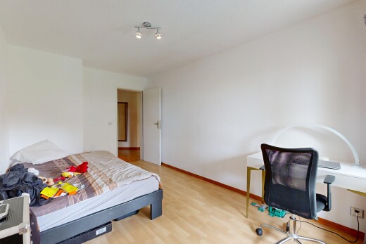 chambre avec cloison sèche, drywall, espace bureau, sol en finition bois, et wood finish floor