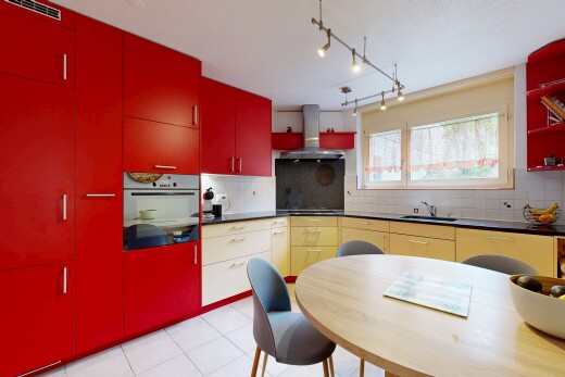 cuisine avec armoires rouges, red cabinets, plans de travail, dark countertops, et four