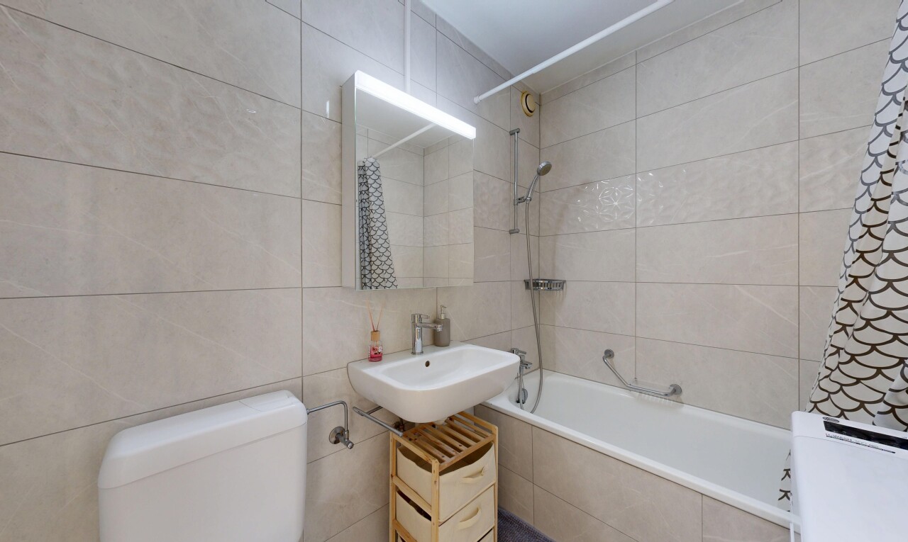 salle de bains avec mur en carrelage, tile wall, toilette, salle de bain complète, et miroir