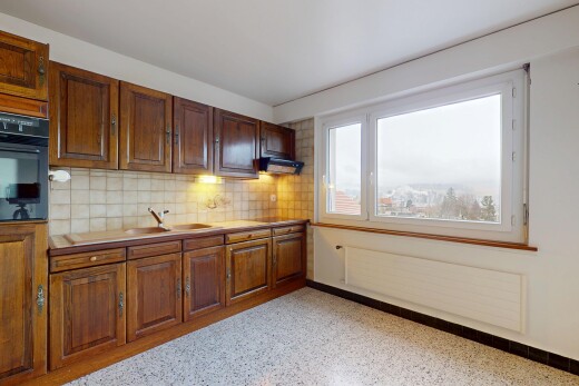 küche mit hochgezogene schränke, ofen, natürliches licht, küchenrückwand beim herd, und waschbecken