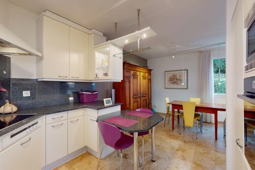 küche mit arbeitsplatten, küchenrückwand beim herd, weiße schränke, natürliches licht, und dunstabzugshaube