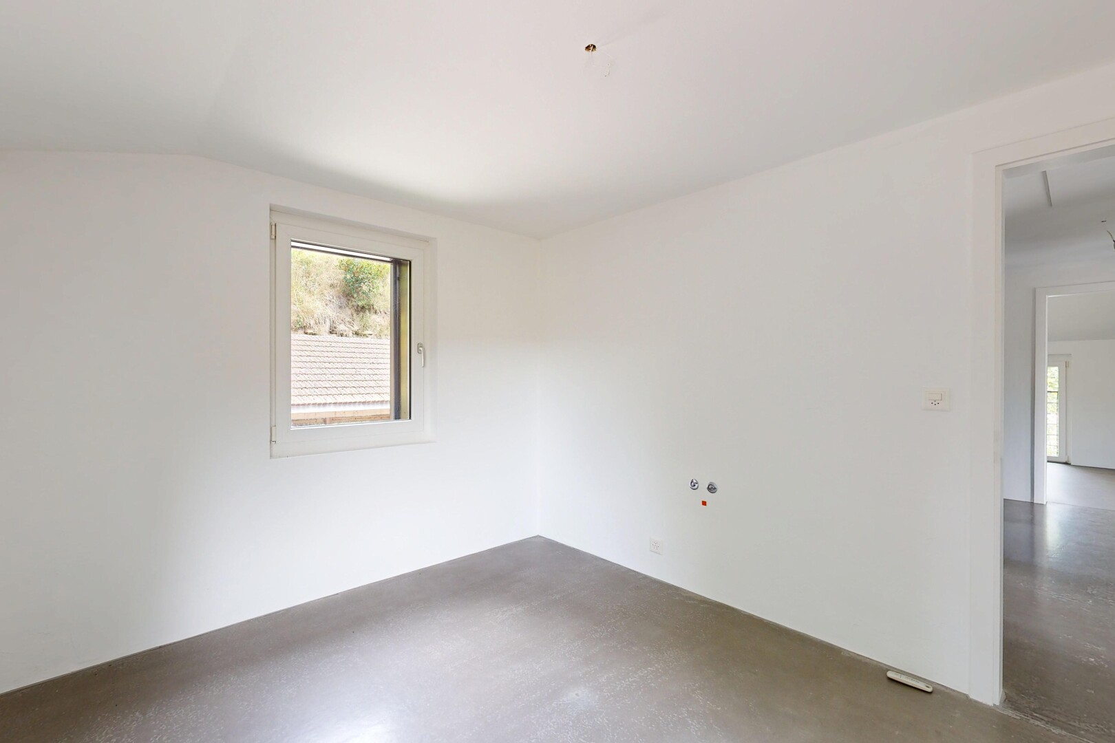 empty room with lofted ceiling and concrete floors