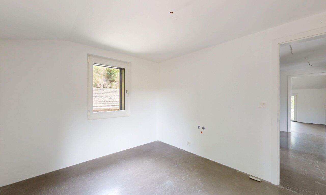 empty room with lofted ceiling and concrete floors