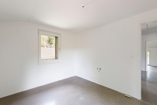 empty room with lofted ceiling and concrete floors
