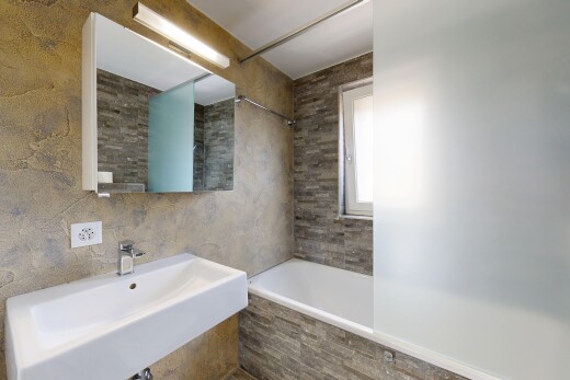 full bathroom featuring tiled shower / bath combo and tile walls