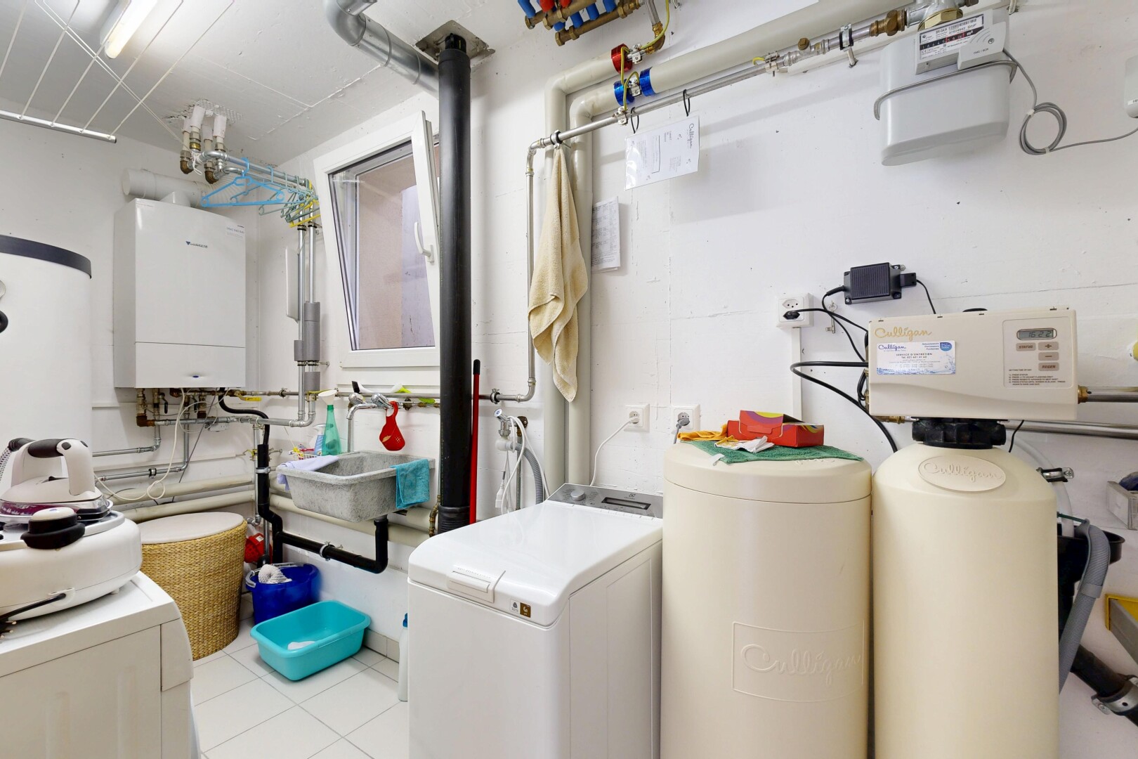 buanderie avec buanderie, chauffe-eau, inside property, lave-linge et sèche-linge séparés, et sol en carrelage