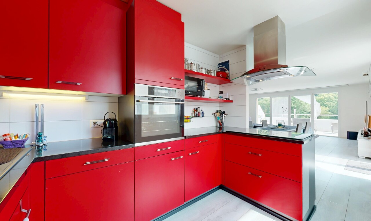 cuisine avec armoires rouges, four, hotte, inside property, et natural light
