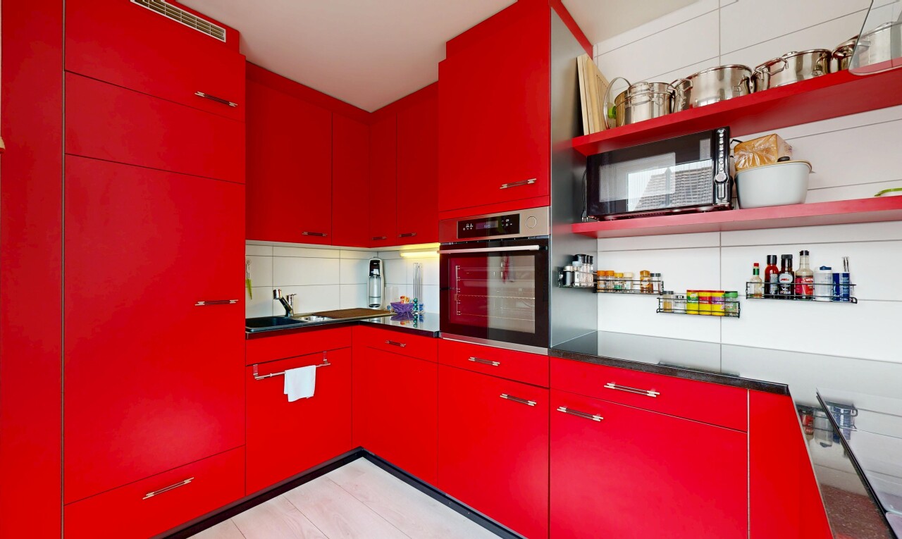 cuisine avec armoires rouges, four, étagères ouvertes, inside property, et plans de travail