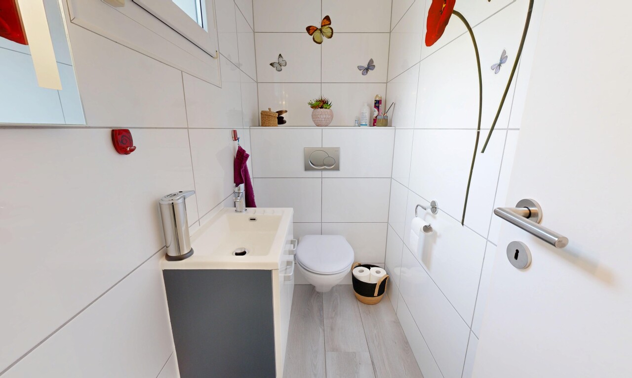 salle de bains avec mur en carrelage, tile wall, lavabo (ou coiffeuse selon le contexte), toilette, et inside property