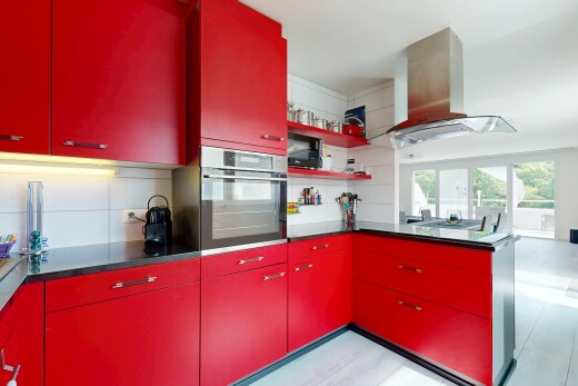 cuisine avec armoires rouges, four, hotte, inside property, et natural light