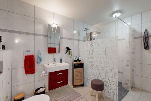 salle de bains avec mur en carrelage, tile wall, lavabo (ou coiffeuse selon le contexte), douche, et sol en carrelage