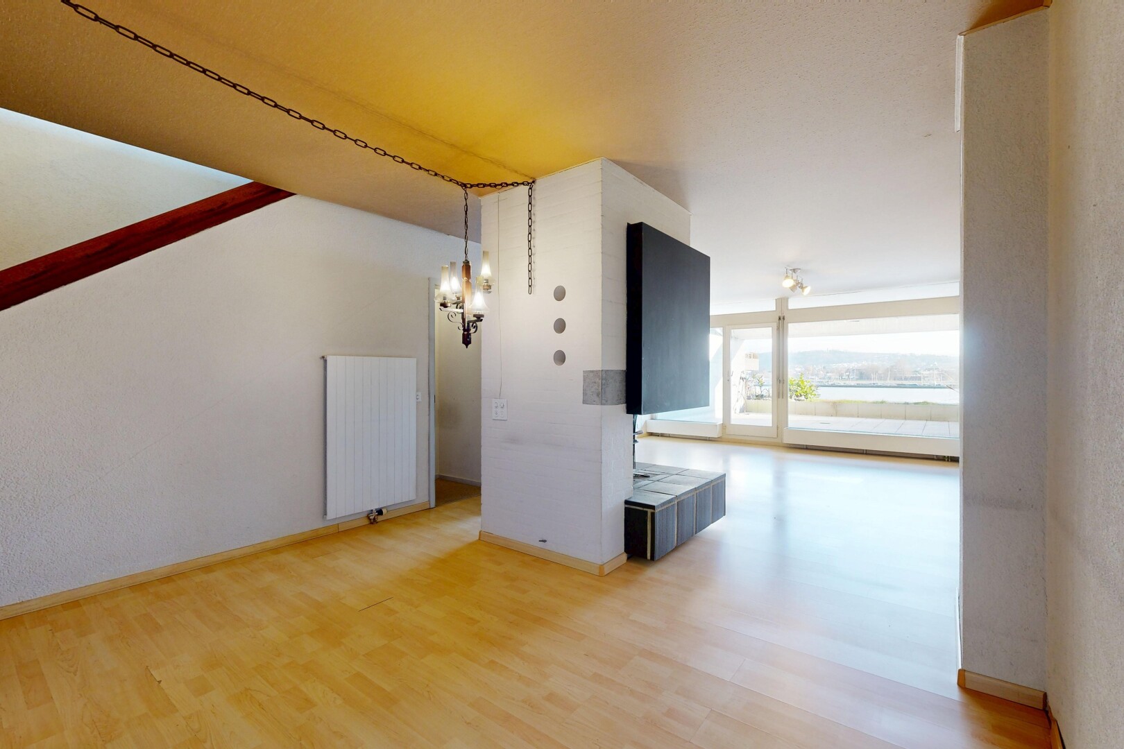 pièce vide avec lumière naturelle, natural light, radiateur, inside property, et sol en finition bois
