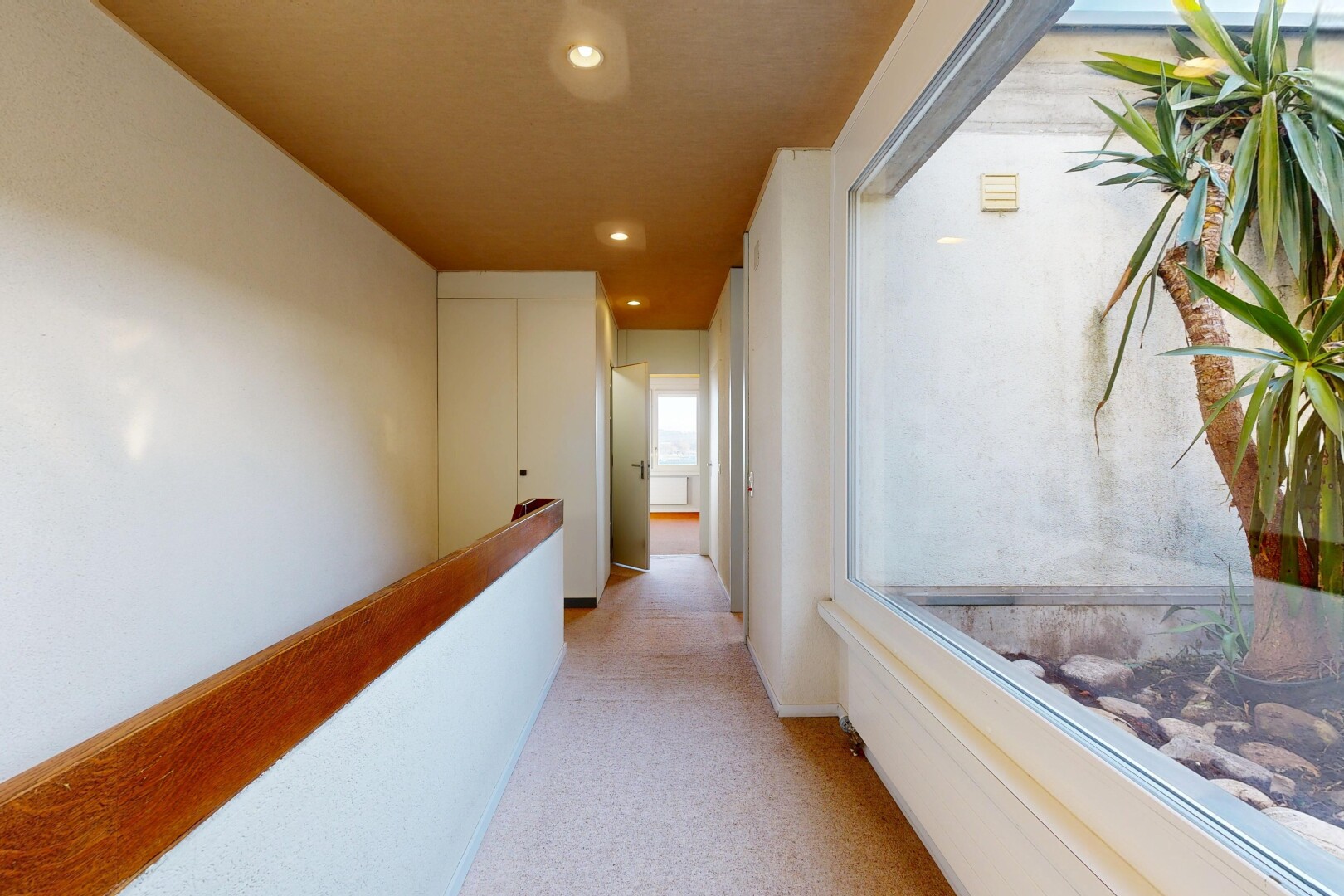 couloir avec moquette, carpet, cloison sèche, drywall, et éclairage encastré