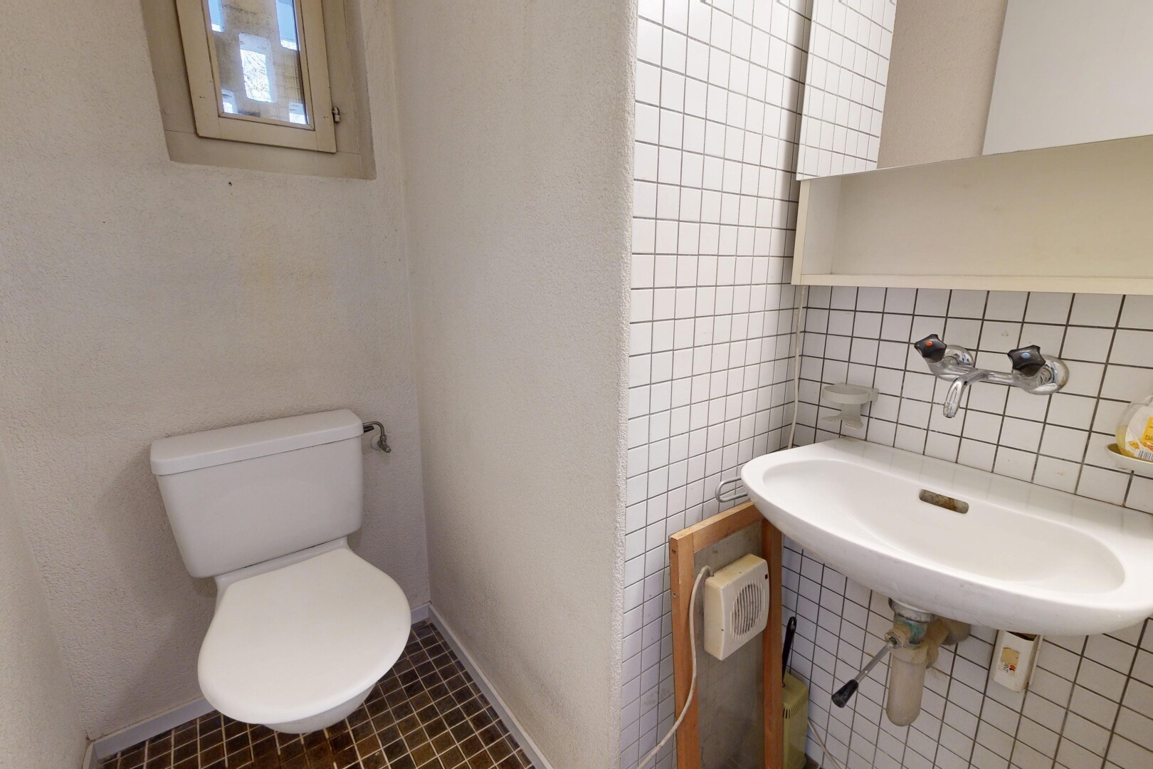 salle de bains avec inside property, mur en carrelage, tile wall, toilette, et évier