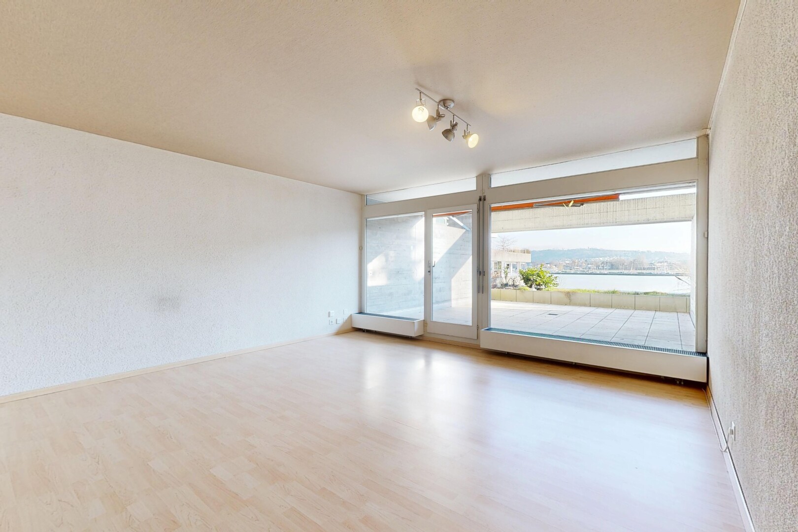 pièce vide avec mur texturé, textured wall, sol en finition bois, wood finish floor, et inside property