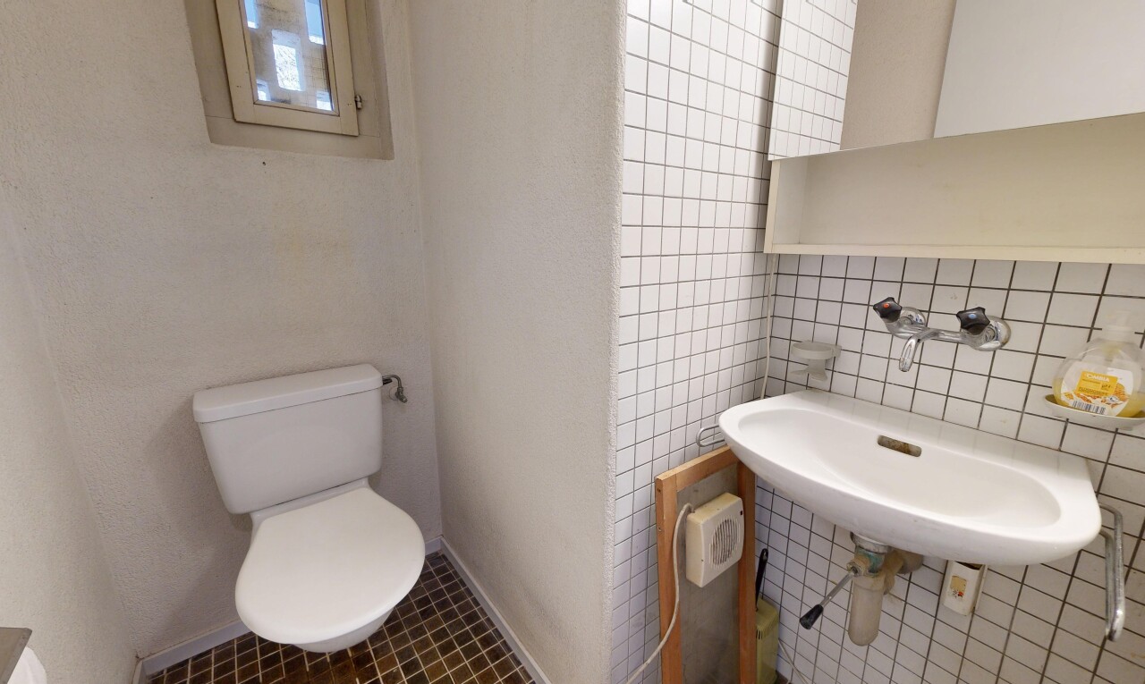 salle de bains avec inside property, mur en carrelage, tile wall, toilette, et évier