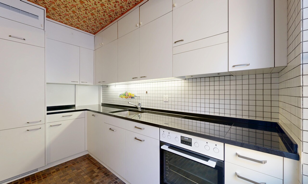 cuisine avec four, plans de travail, armoires blanches, inside property, et dosseret