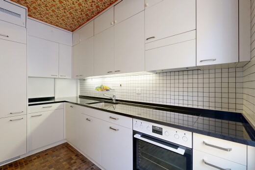 küche mit ofen, arbeitsplatten, weiße schränke, inside property, und küchenrückwand beim herd