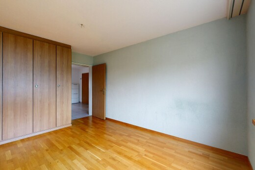 zimmer / schlafzimmer mit kleiderschrank, holzfußboden, wood finish floor, gipskartonwand, und drywall