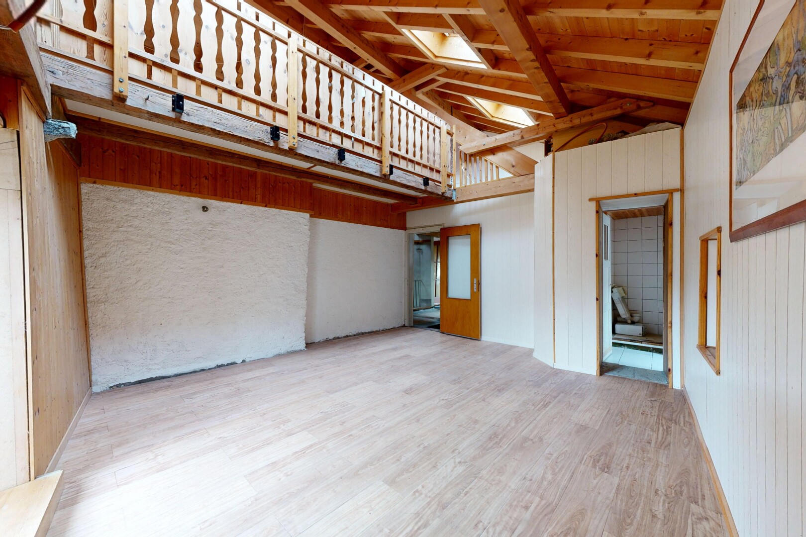 leerer raum mit holzwand, wood wall, inside property, dachschräge, und vaulted ceiling