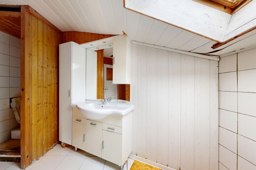 half bathroom with vanity, wood walls, and light tile patterned flooring