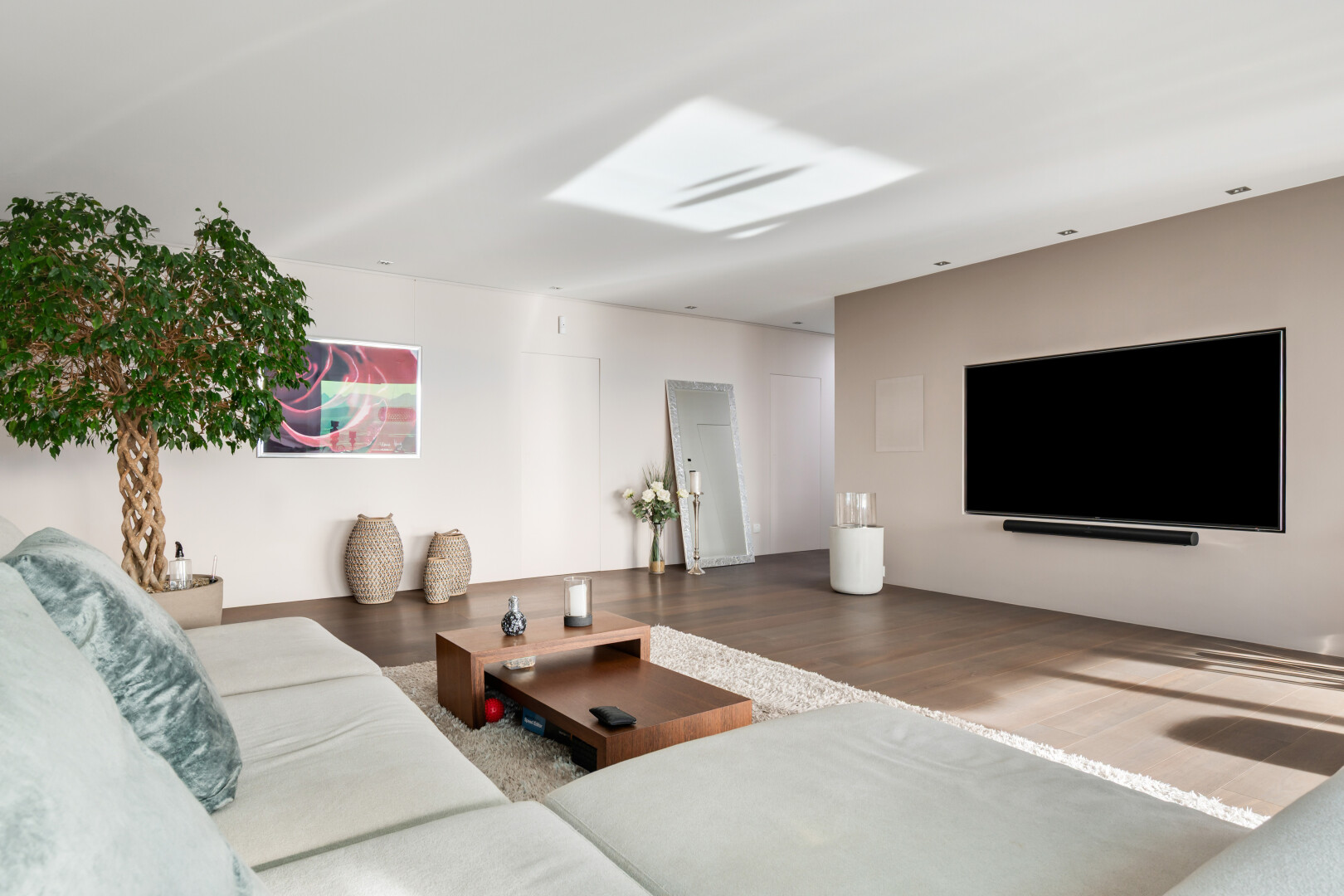 salon avec télévision, cloison sèche, drywall, inside property, et sol en finition bois