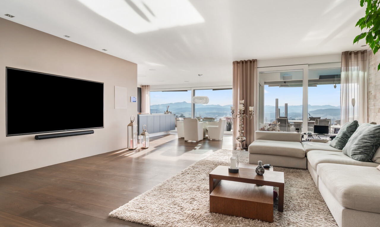 salon avec inside property, télévision, sol en finition bois, wood finish floor, et lumière naturelle