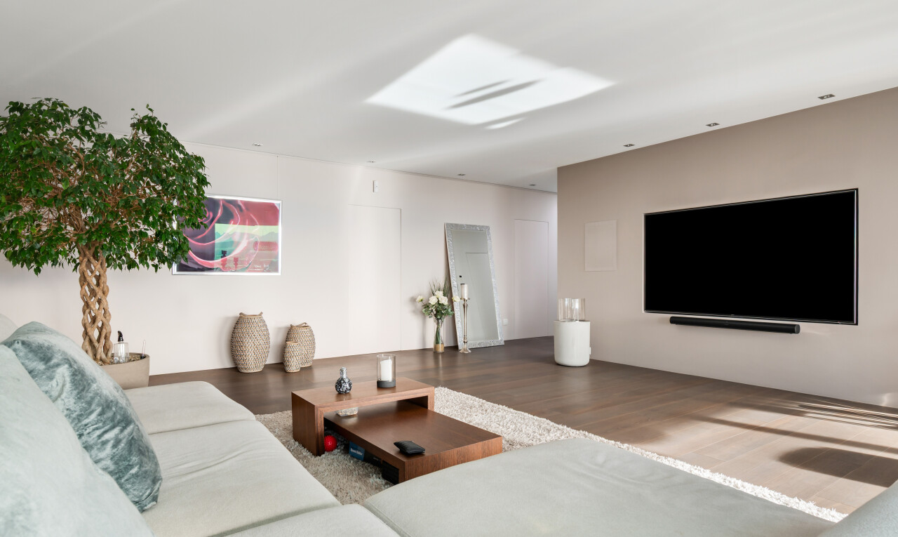 salon avec télévision, cloison sèche, drywall, inside property, et sol en finition bois