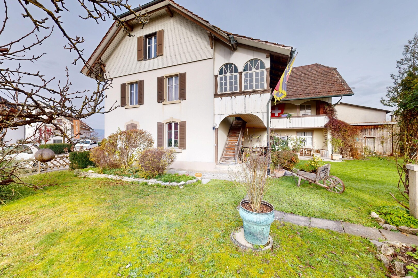 façade avec property visible, pelouse, bardage en stuc, balcon, et escaliers