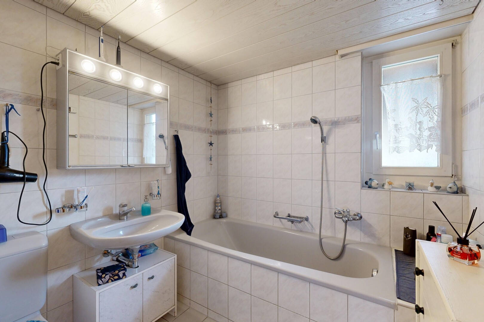 salle de bains avec tile wall, mur en carrelage, salle de bain complète, inside property, et miroir