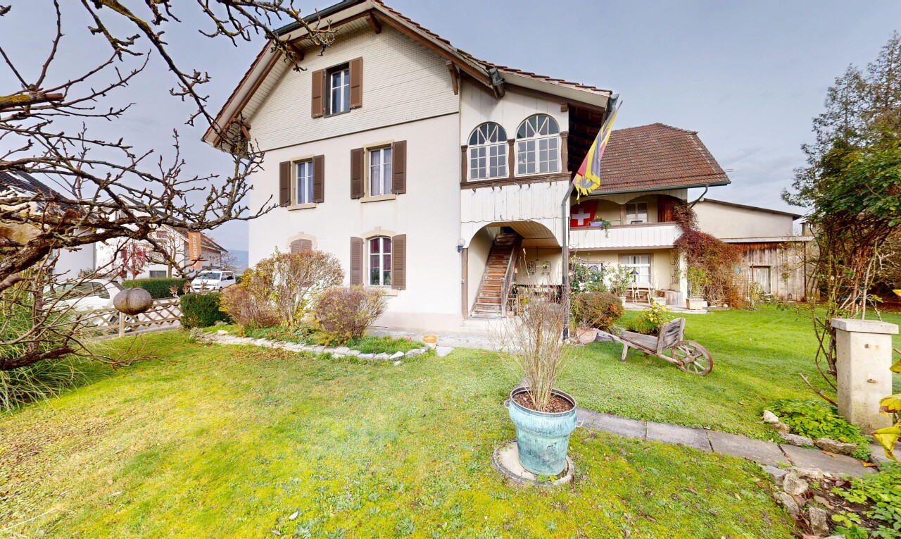 façade avec property visible, pelouse, bardage en stuc, balcon, et escaliers