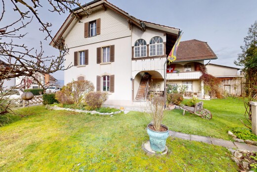 façade avec property visible, pelouse, bardage en stuc, balcon, et escaliers