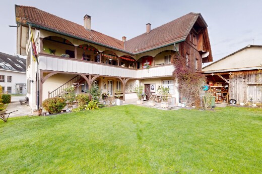 façade avec balcon, terrasse, property visible, pelouse, et cheminée