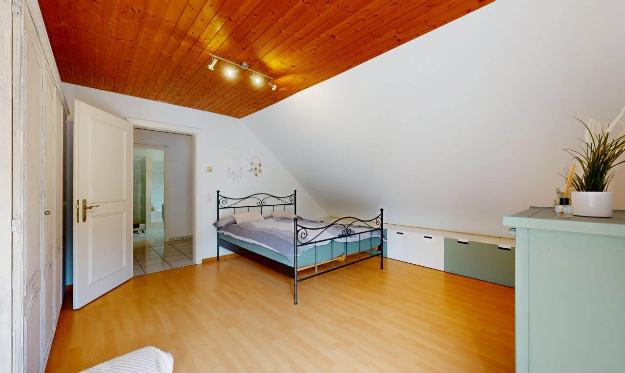 zimmer / schlafzimmer mit track lighting, deckenbeleuchtung, drywall, gipskartonwand, und wood finish floor