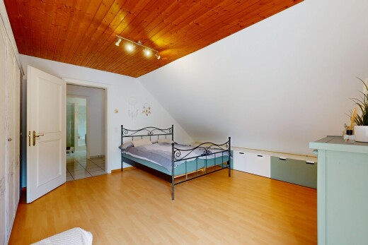 zimmer / schlafzimmer mit track lighting, deckenbeleuchtung, drywall, gipskartonwand, und wood finish floor