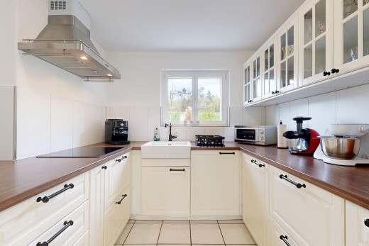 cuisine avec hotte, raised cabinets, armoires élevées, light floor, et inside property