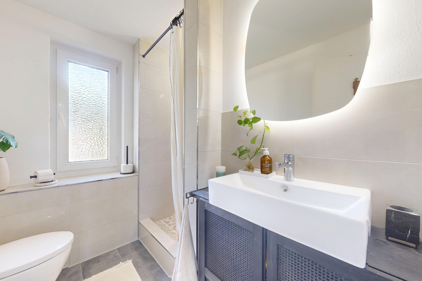 salle de bains avec miroir, douche, lavabo (ou coiffeuse selon le contexte), salle de bain complète, et toilette