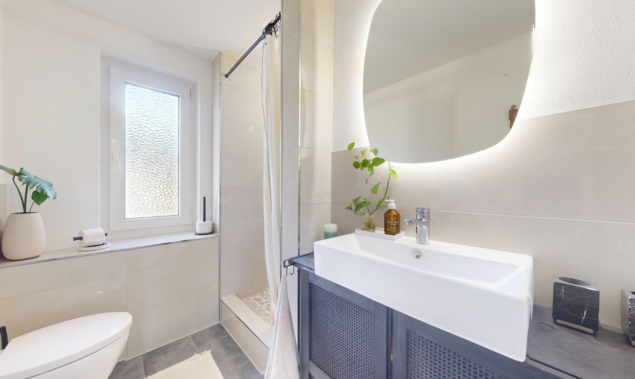 salle de bains avec miroir, douche, lavabo (ou coiffeuse selon le contexte), salle de bain complète, et toilette