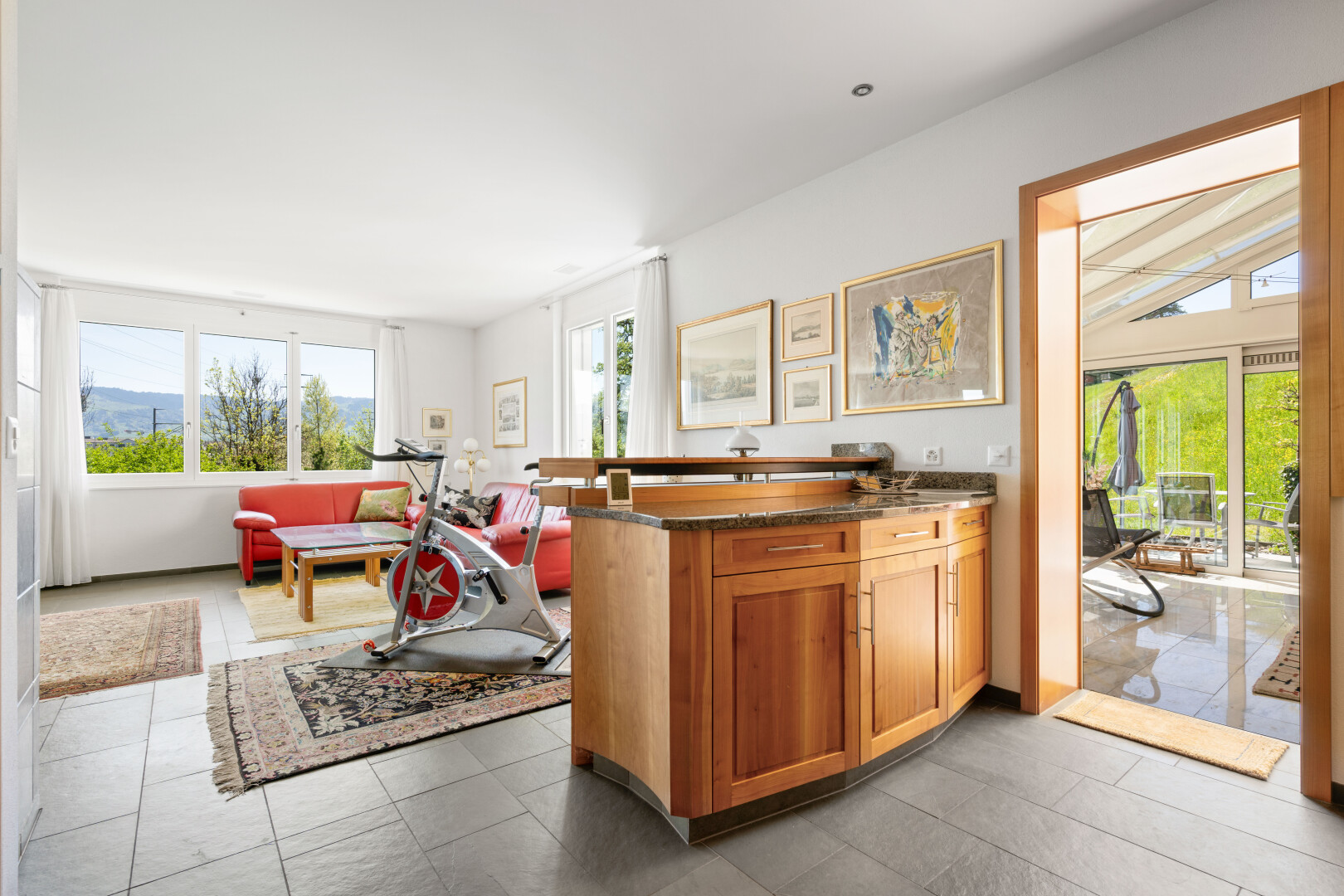 kitchen with open floor plan, wood finish cabinetry, dark stone countertops, and a peninsula
