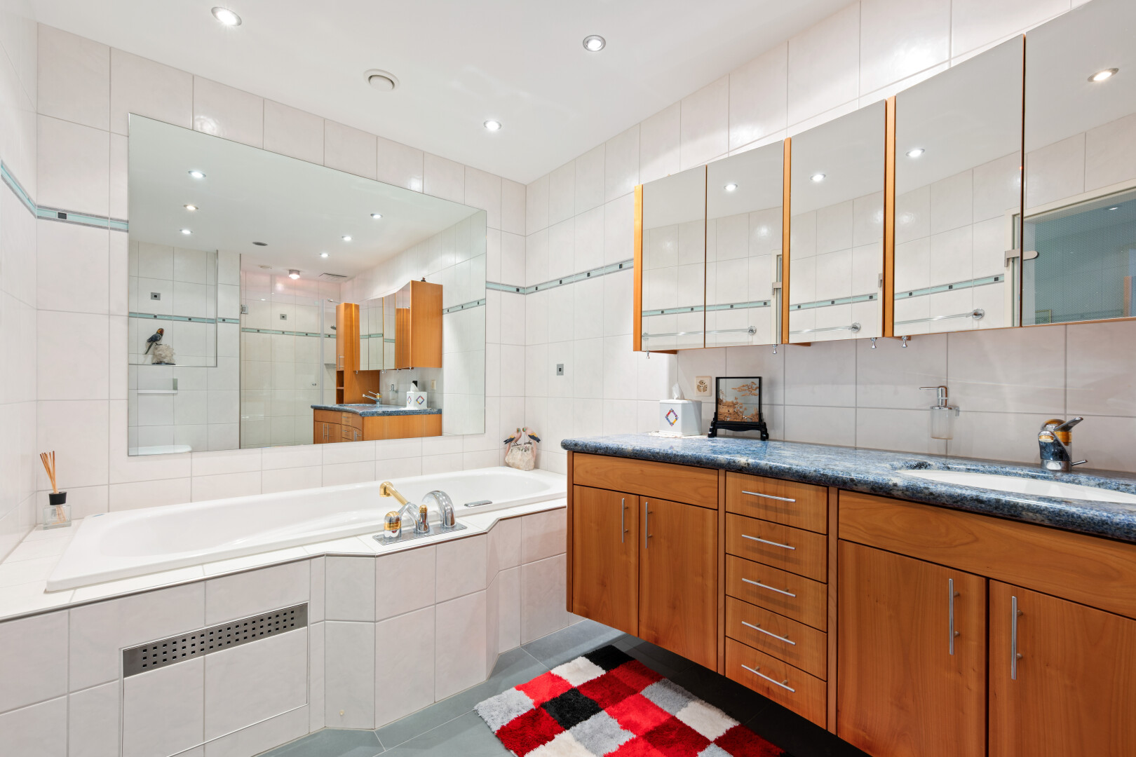 two tone kitchen featuring tile walls, dark tile patterned flooring, recessed lighting, two tone color scheme, and glass insert cabinets