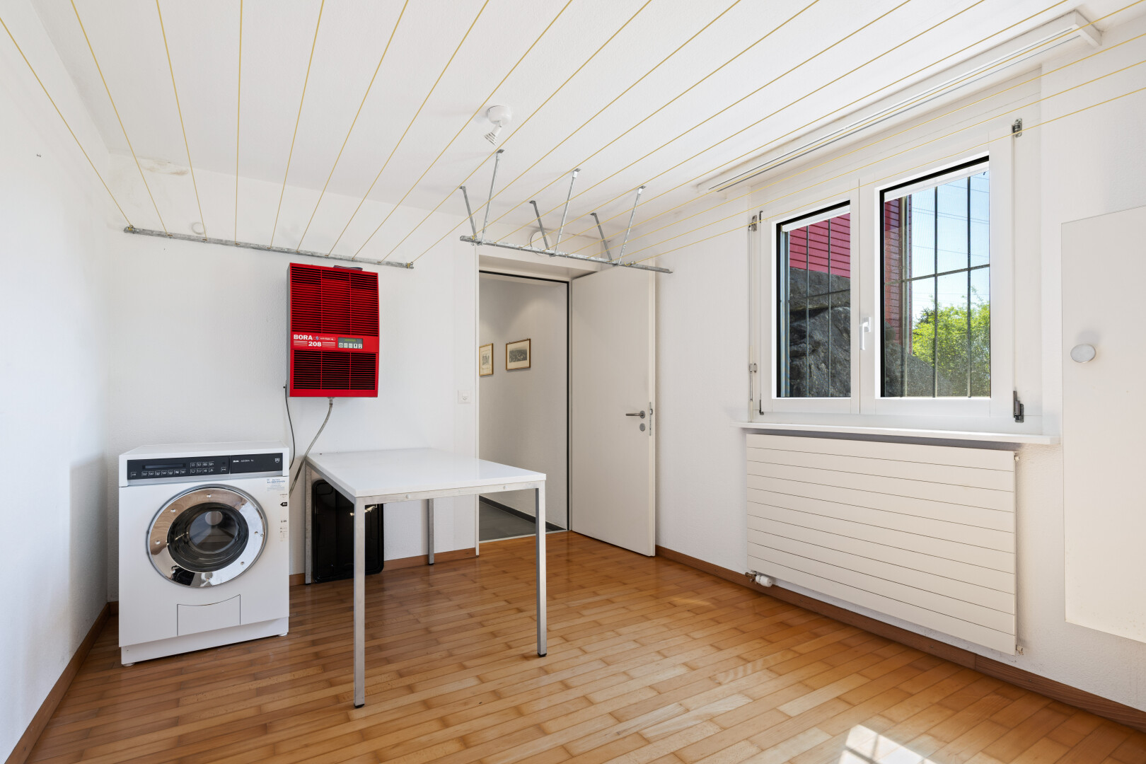 laundry room with washer / clothes dryer, radiator, and light wood-style floors