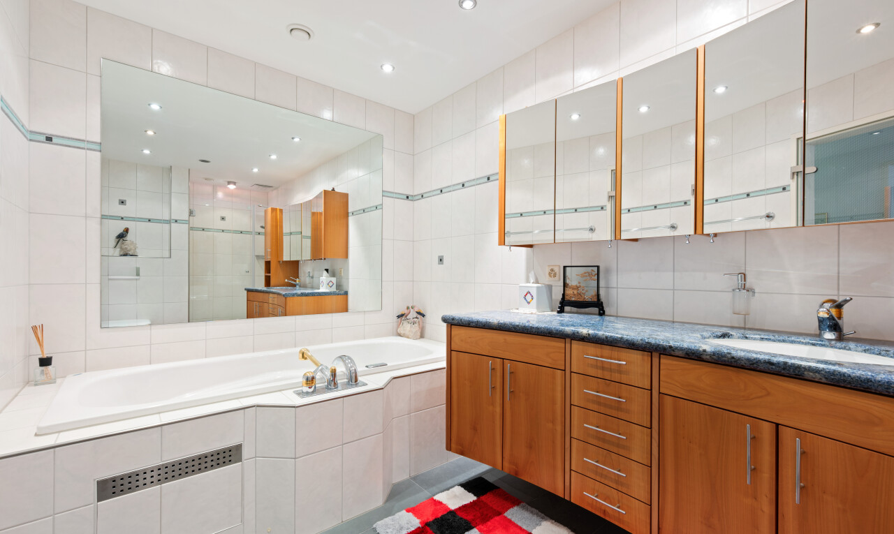 two tone kitchen featuring tile walls, dark tile patterned flooring, recessed lighting, two tone color scheme, and glass insert cabinets