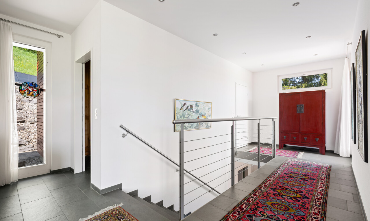 hallway featuring an upstairs landing and recessed lighting