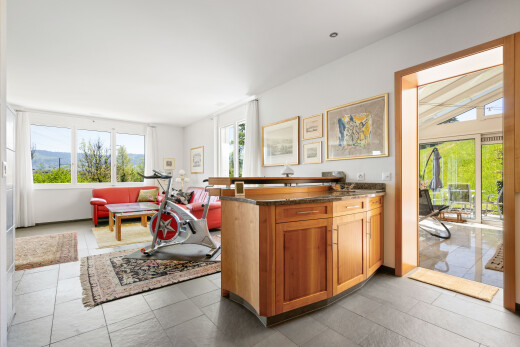 kitchen with open floor plan, wood finish cabinetry, dark stone countertops, and a peninsula