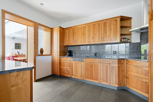 kitchen featuring open shelves, tasteful backsplash, dark stone countertops, dishwasher, and dark tile patterned flooring