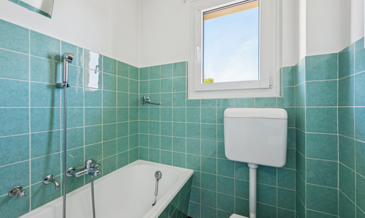 full bathroom with tile walls and a wainscoted wall